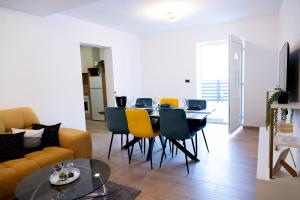 a living room with a couch and a table and chairs at Apartmani Nil in Barić Draga