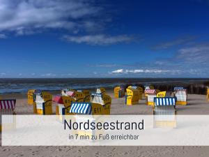 a group of chairs sitting on the beach at Strandloft Cuxhaven im Haus Frauenpreiß Sahlenburg - strandnah - 2 Hunde willkommen -Schwimmbad - Sauna - direkt am Wald - Dachterrasse mit Blick nach Neuwerk in Cuxhaven