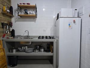 a small kitchen with a sink and a refrigerator at Residencial Makai in Itapoa