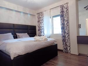 a bedroom with a bed with two towels on it at Seferi4suite Ioannina in Eleoúsa +15 photos