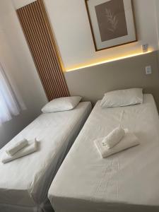 two beds sitting next to each other in a room at Apartamento no centro da cidade in Serra Negra