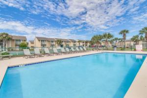 einen großen Pool mit Liegestühlen und Eigentumswohnungen in der Unterkunft Double Take! Renovated Vacation Home in Panama City Beach