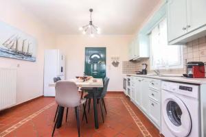 a kitchen with a table and chairs in a room at Maison See View in Kontokali