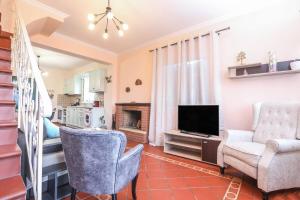 a living room with two chairs and a television at Maison See View in Kontokali