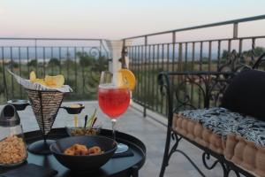 a table with a drink and a bowl of food on a balcony at Casa La Giuggiola in Fiano Romano