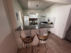 a kitchen with two bar stools and a counter top at Casa do Marcus in Barra do Garças
