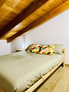 Ce lit se trouve dans une chambre dotée d'un plafond en bois. dans l'établissement Villa Bubù, Appartamento Country-chic, à Rome