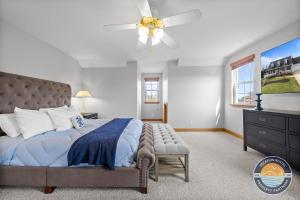 Chic Lake Geneva Retreat Spring & Summer Getaway Near Lake & Golf في بحيرة جنيف: غرفة نوم بها سرير ومروحة سقف