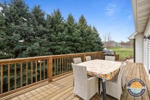 Chic Lake Geneva Retreat Spring & Summer Getaway Near Lake & Golf في بحيرة جنيف: سطح خشبي به طاولة وكراسي