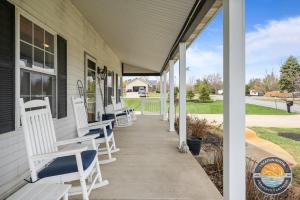 Chic Lake Geneva Retreat Spring & Summer Getaway Near Lake & Golf في بحيرة جنيف: شرفة مع كراسي بيضاء على المنزل