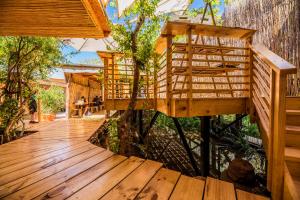 a wooden deck with a tree house on it at Hostal Copart in San Pedro de Atacama
