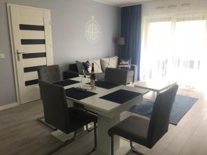 a living room with a dining room table and chairs at Morski z ogródkiem in Pogorzelica