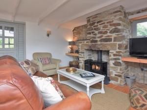 a living room with a couch and a fireplace at Riverside barn on private wildlife estate in Washaway +55 photos