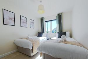 ein Schlafzimmer mit zwei Betten und einem Fenster in der Unterkunft Home Private Parking, Sleeps 8, Contractors Welcome in Lemington