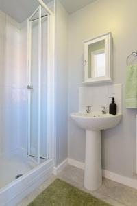 ein weißes Badezimmer mit Waschbecken und Dusche in der Unterkunft Home Private Parking, Sleeps 8, Contractors Welcome in Lemington