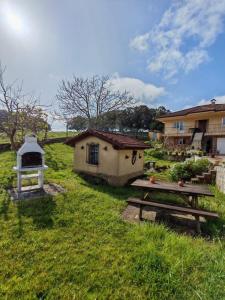 a building with a picnic table and a house at Apartamento con jardín in La Franca