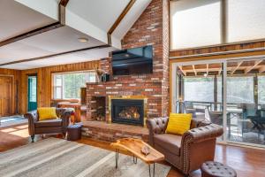 a living room with a brick fireplace and chairs at Haverhill Mtn Retreat Hike, Ski, Relax in Hot Tub in Woodsville
