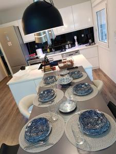 a table with plates and glasses on it in a kitchen at Seferi4suite Ioannina in Eleoúsa