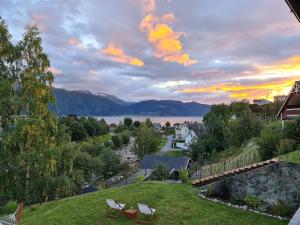 a view of a lake with two chairs on a lawn at Over the Fjord in Leikanger
