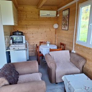 a living room with couches and a table and a kitchen at Cottage Kolomza in Ulcinj