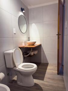 Ubicación y todo para tu desayuno في ميندوزا: حمام مع مرحاض أبيض ومغسلة