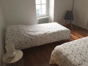a bedroom with two beds and a window at Maison Cosy centre de Pouzauges in Pouzauges