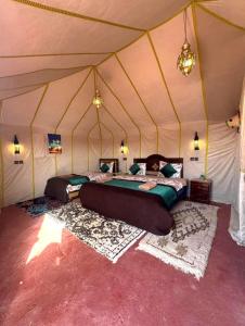 梅尔祖卡Merzouga Comfortable Camps的帐篷里有两张床的房间