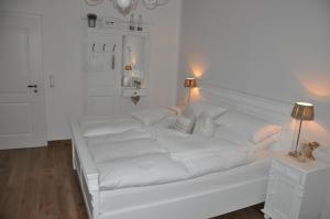 ein weißes Sofa in einem weißen Zimmer mit zwei Lampen in der Unterkunft White Cottage Garden in Cloppenburg