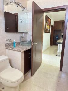 a bathroom with a toilet and a sink and a sink at Amplio Departamento cerca del Jardín Principal de Sayula in Sayula