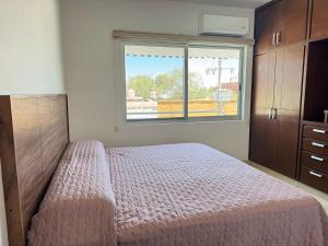 a bedroom with a bed with a large window at Amplio Departamento cerca del Jardín Principal de Sayula in Sayula