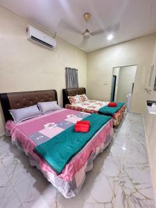 a bedroom with two beds and a air conditioner at Teratak Cikgu Roomstay 2 in Kampong Tok Barat +21 photos