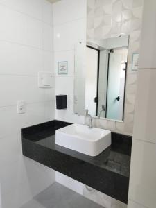 a white bathroom with a sink and a mirror at Casa de Praia Família Próximo ao ExpoCentro BC in Balneário Camboriú