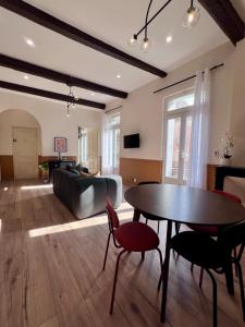 ein Wohnzimmer mit Tisch und Couch in der Unterkunft Féria apartment city center in Béziers