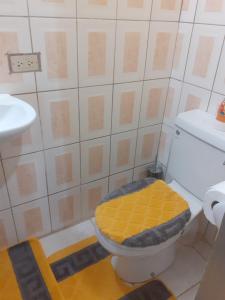 a bathroom with a toilet with a yellow seat at Essentials Suite in Bon Accord +19 photos
