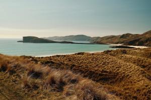 a view of a beach and the ocean at Eco Crofter's Wagon by the Sea - Off Grid Experience - No electricity - As seen soon on Netflix in Oldshoremore
