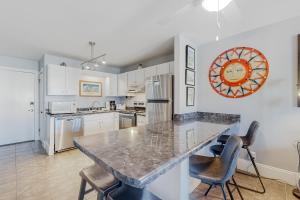 a kitchen with a marble counter top and chairs at Plantation East #1110 in Gulf Shores