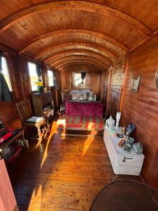 a bedroom with a bed in a wooden room at Eco Crofter's Wagon by the Sea - Off Grid Experience - No electricity - As seen soon on Netflix in Oldshoremore