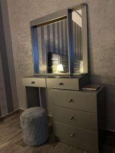a dresser with a mirror and a stool in a room at Luxurious apartment in Chefchaouene