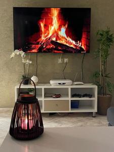 a fireplace in a living room with a tv on a wall at Luxurious apartment in Chefchaouene