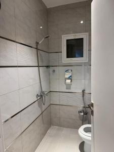 a bathroom with a toilet and a tv on the wall at شقة فاخرة in Taif
