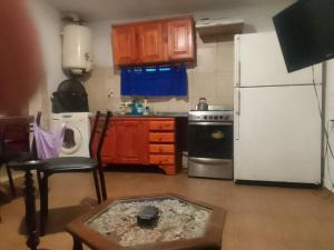 a kitchen with a white refrigerator and a table at Arroyo seco playa hermosa in Arroyo Seco