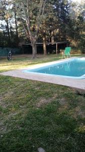 a green chair sitting next to a swimming pool at Arroyo seco playa hermosa in Arroyo Seco