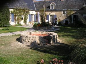 a stone fire pit in the yard of a house at TheSecretGarden-France in Courdemanche