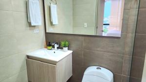 a bathroom with a toilet and a sink and a mirror at Apartamento Luxury ubicado en la mejor zona comercial de la ciudad in Ibagué +19 photos