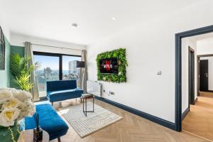 a living room with a blue chair and a window at Western Seaview Terrace - Central - Contractors in Brighton & Hove