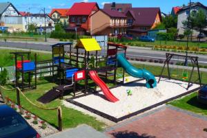 einen Spielplatz mit Rutsche in einem Park in der Unterkunft Villa Dana in Łeba