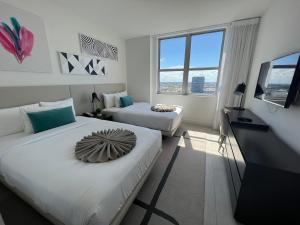 una camera d'albergo con due letti e una televisione di Apt Hyde, Beach, Pool, and Resort Amenities in Miami a Hollywood
