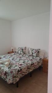 ein Bett in einem Zimmer mit einer weißen Wand in der Unterkunft Vivienda Amanecer in Los Cancajos