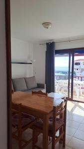 einen Holztisch und Stühle im Wohnzimmer in der Unterkunft Vivienda Amanecer in Los Cancajos