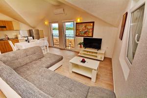 un salon avec un canapé et une télévision dans l'établissement Apartments Bella di Boka, à Tivat